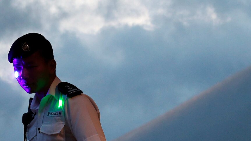 A Hong Kong police officer with purple and green lasers on his face