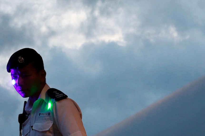 A Hong Kong police officer with purple and green lasers on his face