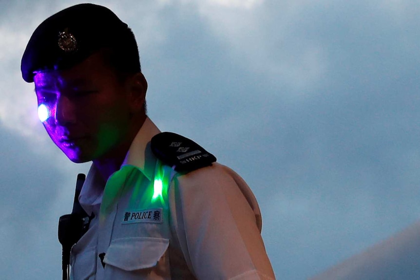 Protesters shoot a laser pen beam on policeman during a march.