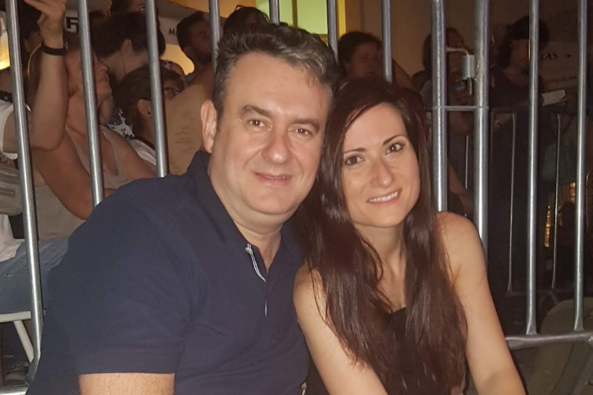 Fotis Larentzakis smiles at the camera with is wife