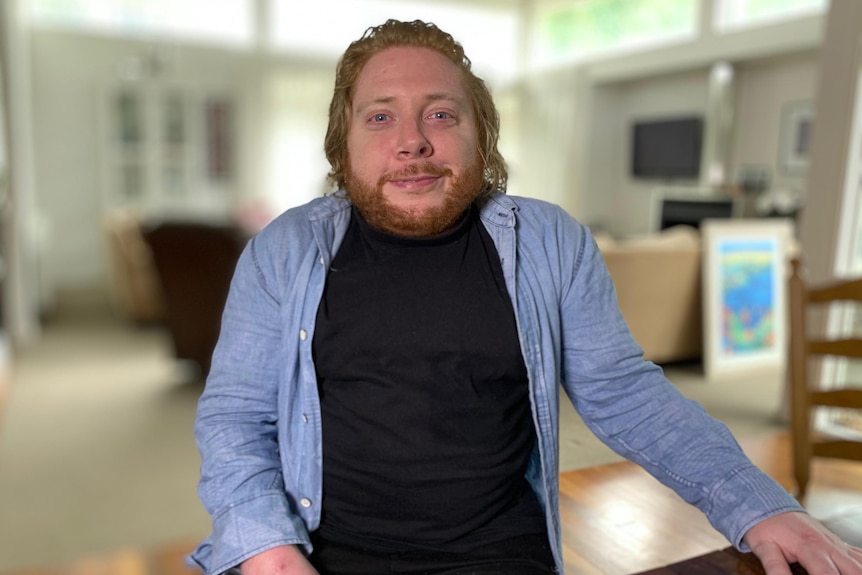 A short -statured man inside a home who is in focus with a blurred background