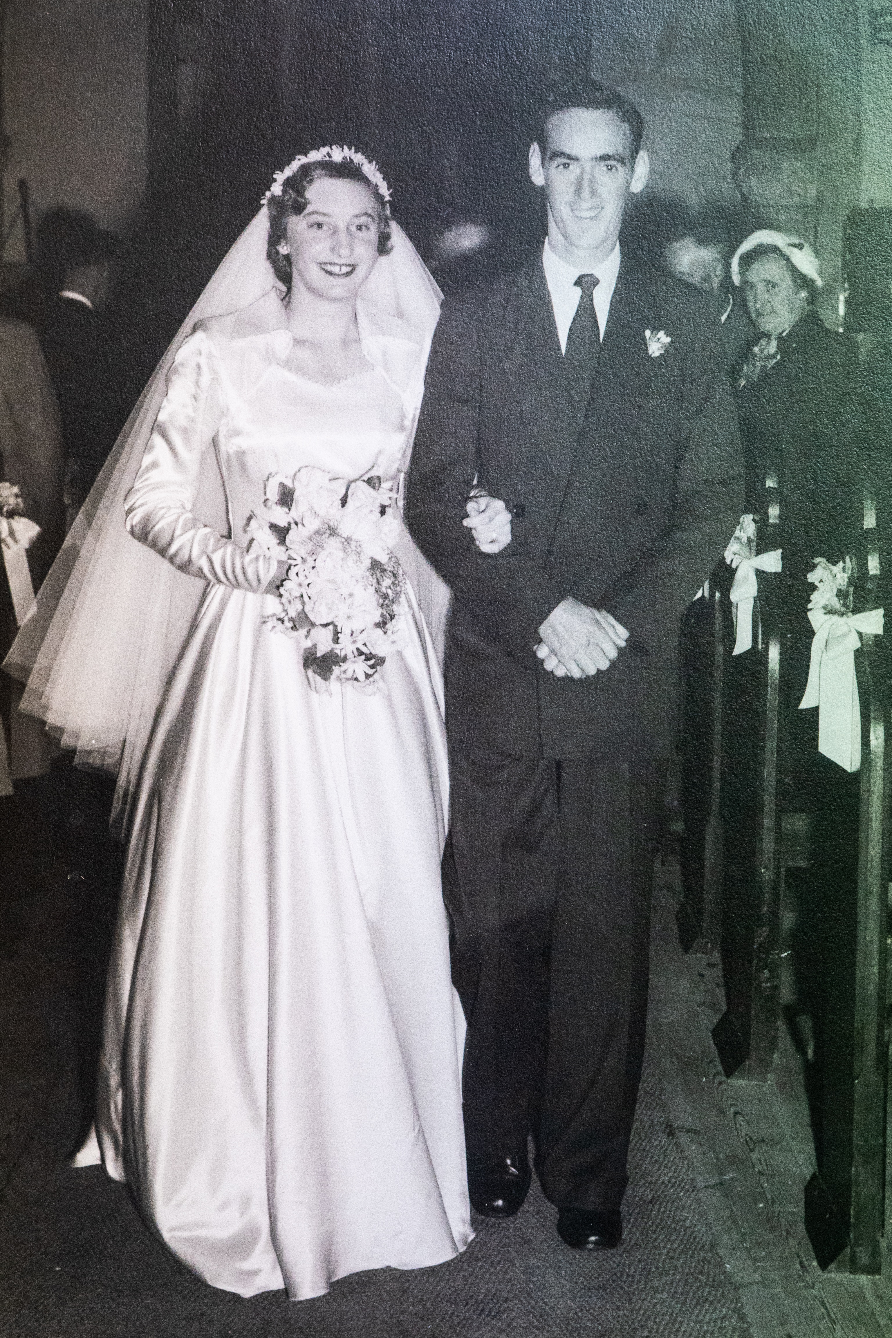 A man in a suit and woman in a wedding dress stand arm in arm. 