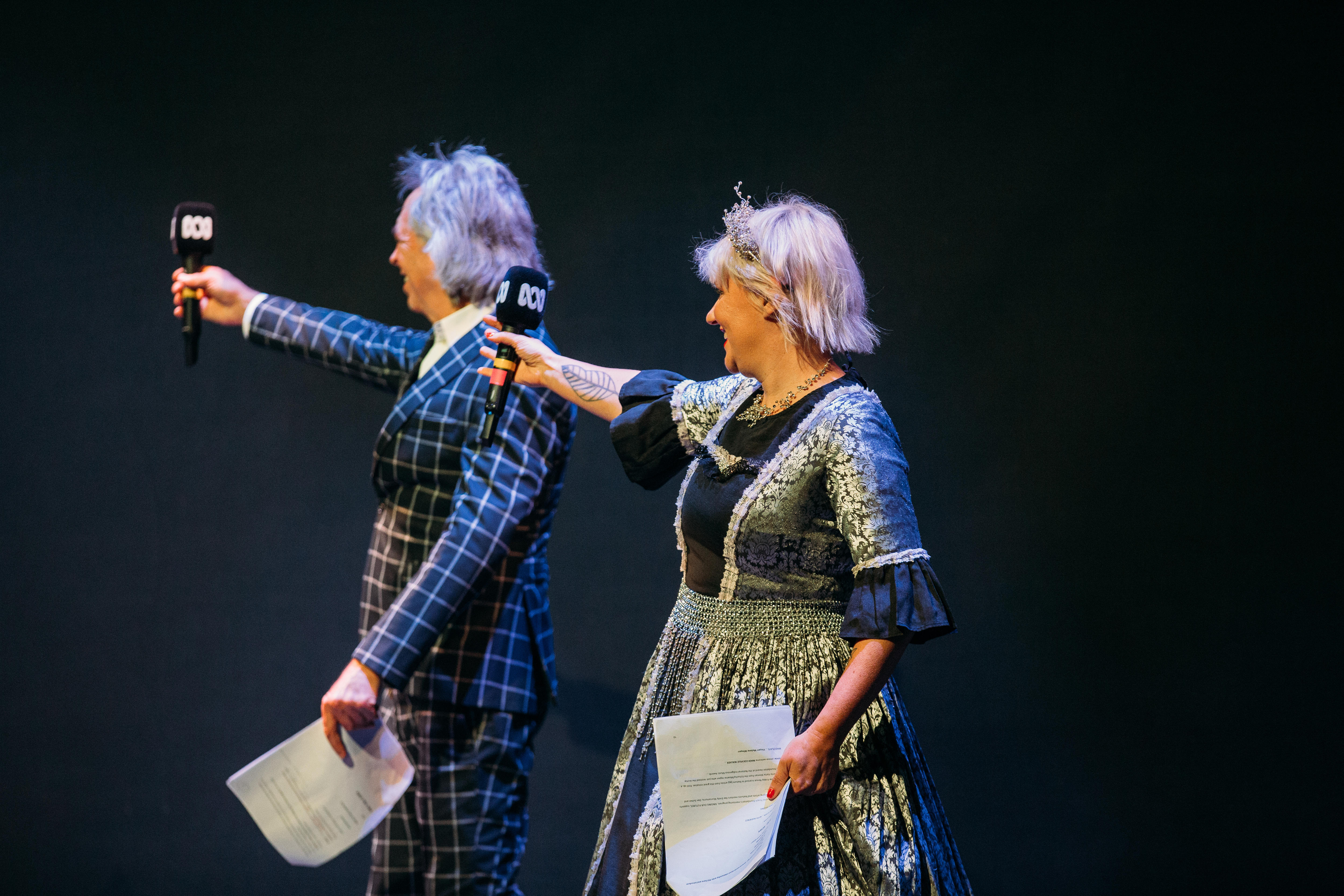 a man in suit and a woman in princess dress on stage