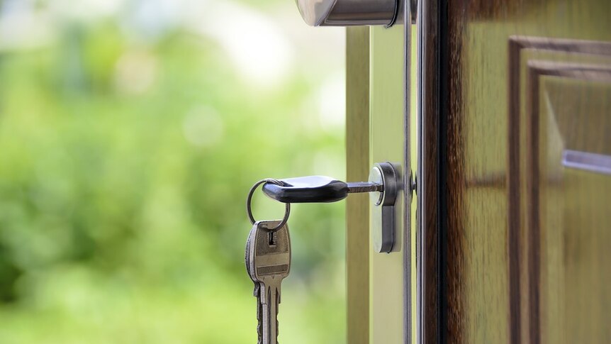 Key in suburban house front door generic image