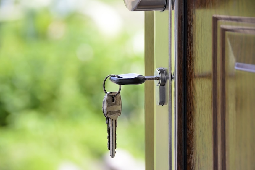 Key in suburban house front door generic image