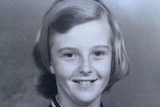 A black and white photo of a smiling teenage girl