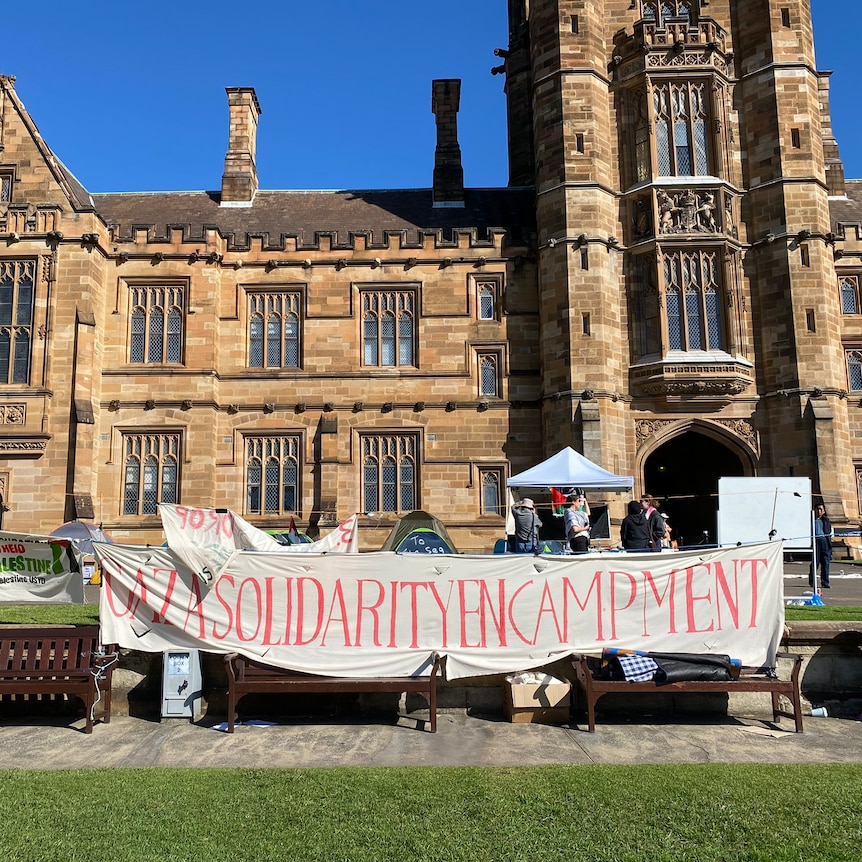 A banner reading 'Gaza solidarity encampment' in front of a historic building at Sydney University