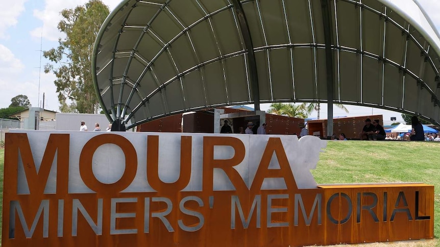 A sign reads Moura Miners' Memorial in front a metal dome structure.