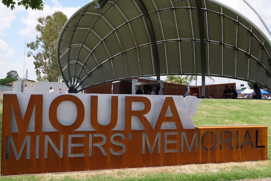 A sign reads Moura Miners' Memorial in front a metal dome structure.