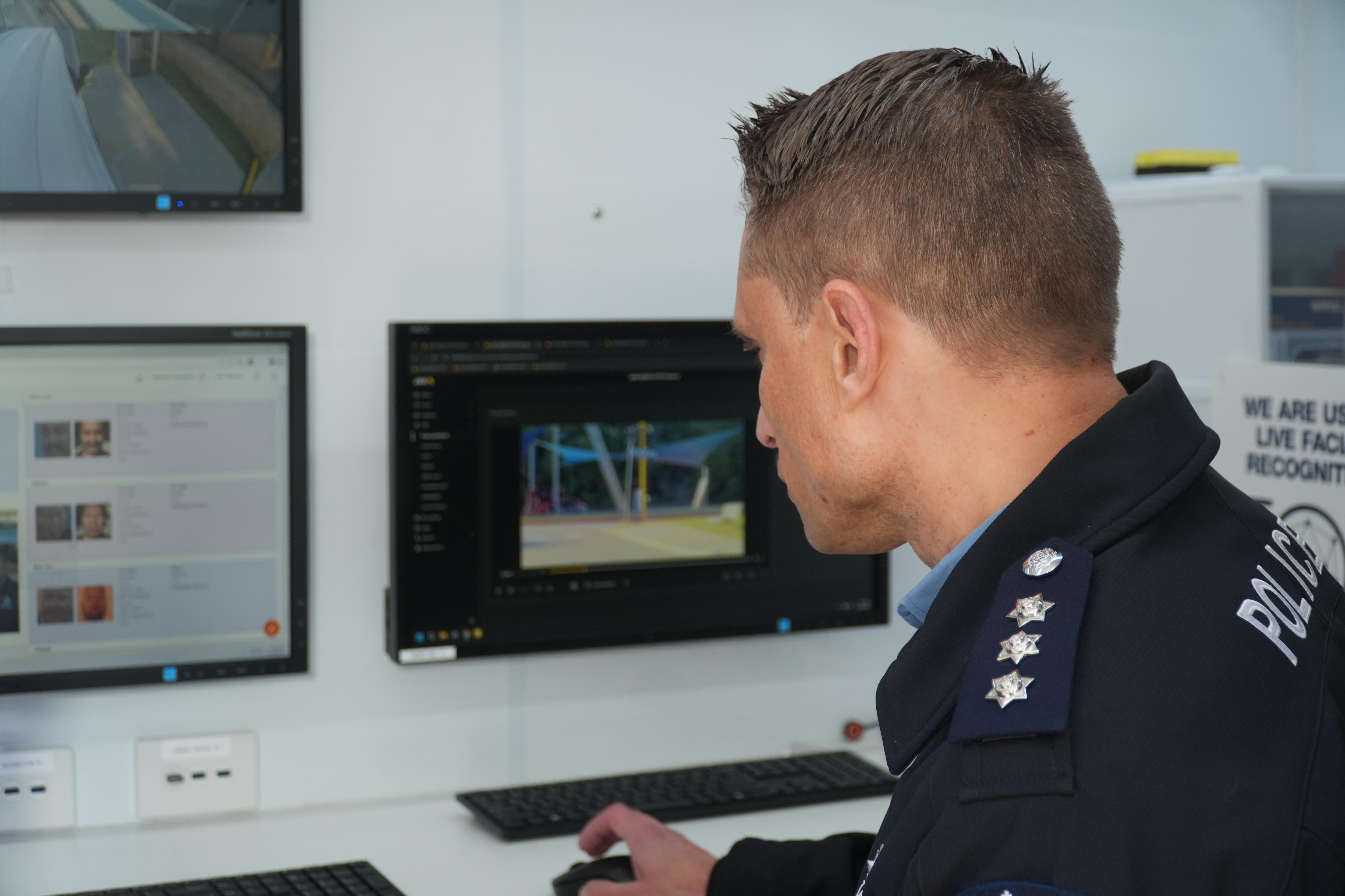 A police officer stares intently at a computer