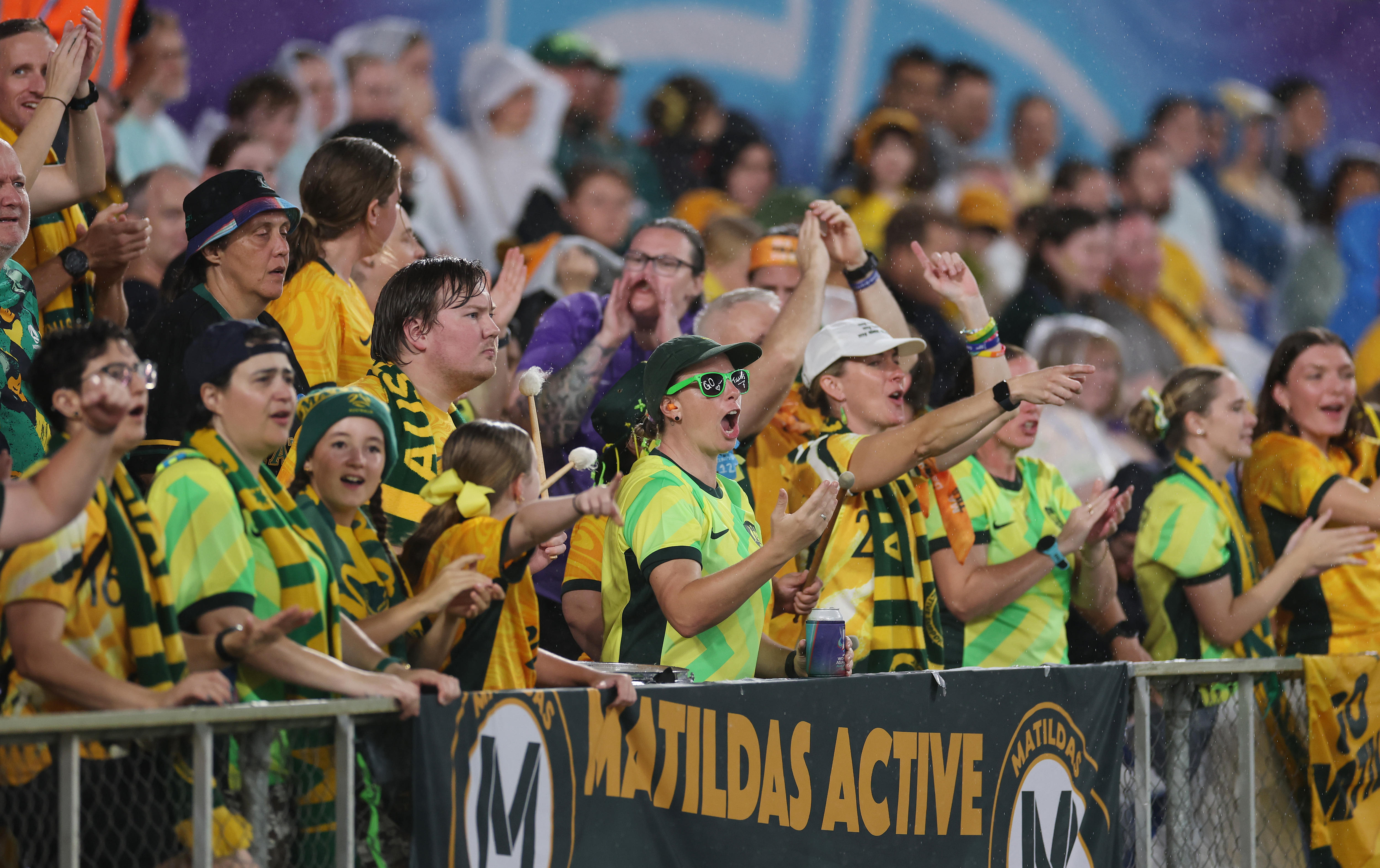 A group of Matildas fans cheer during a game