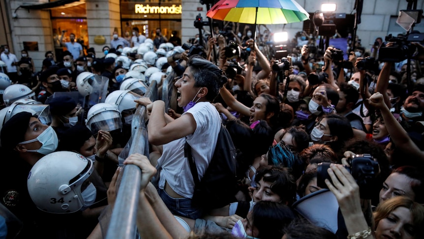 A crowd of women clash against police. 