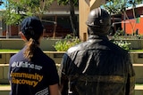 Woman in Lifeline shirt sits next to brass miner statue.