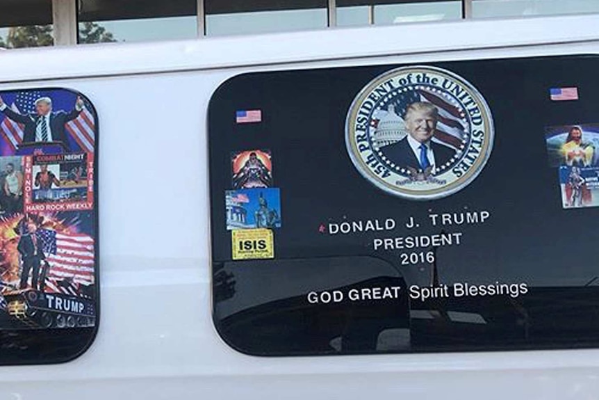 A van with windows covered in pro-Trump and anti-Democrat stickers.
