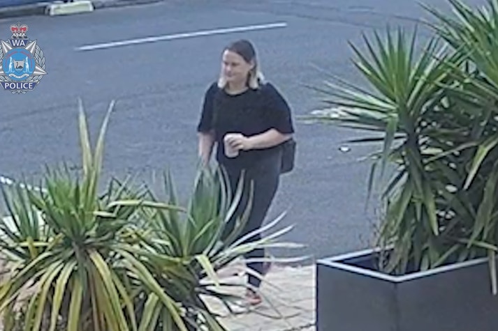 CCTV image of a woman standing in a carpark.