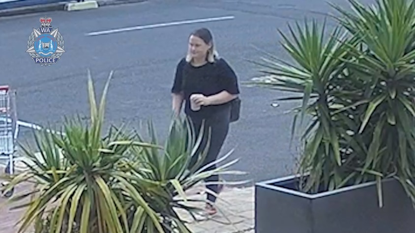 CCTV image of a woman standing in a carpark.