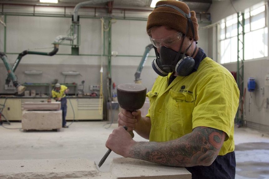 Josiah Gowans chipping away at a stone block