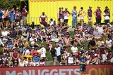Spectators stand and sit on the hill at Brookvale Oval during an NRL match.