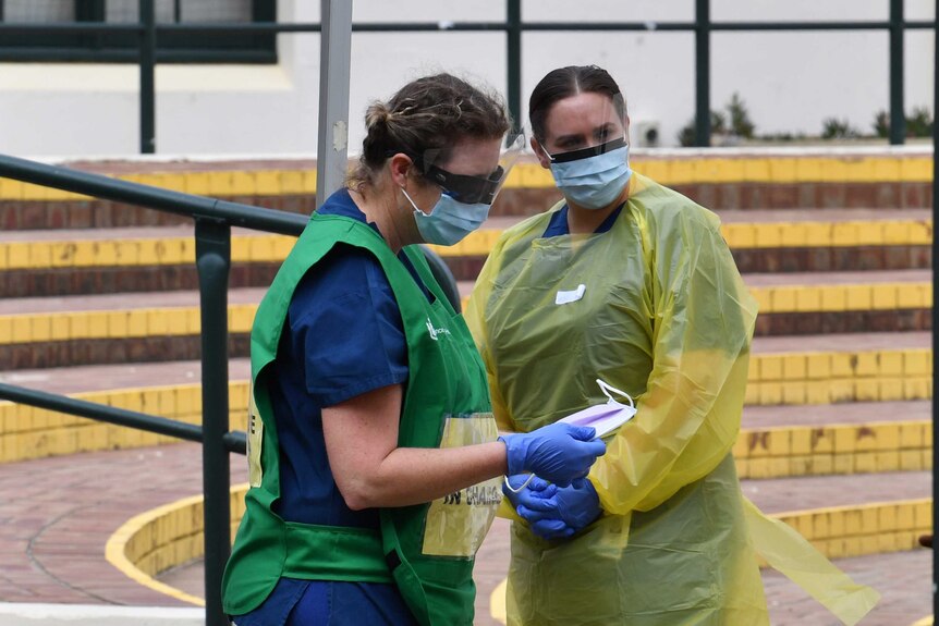 Two nursing staff prepare to work at a COVID-19 testing clinic at Bondi Beach