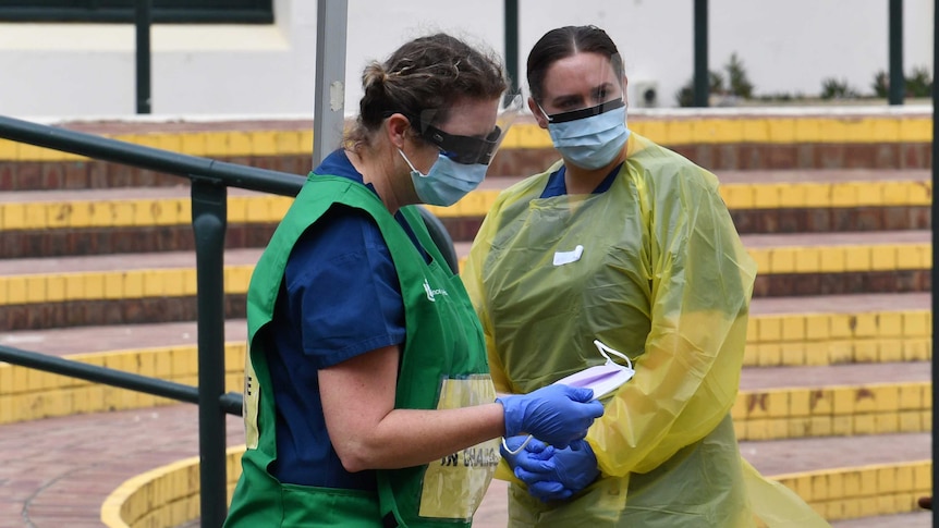 Two nursing staff prepare to work at a COVID-19 testing clinic at Bondi Beach