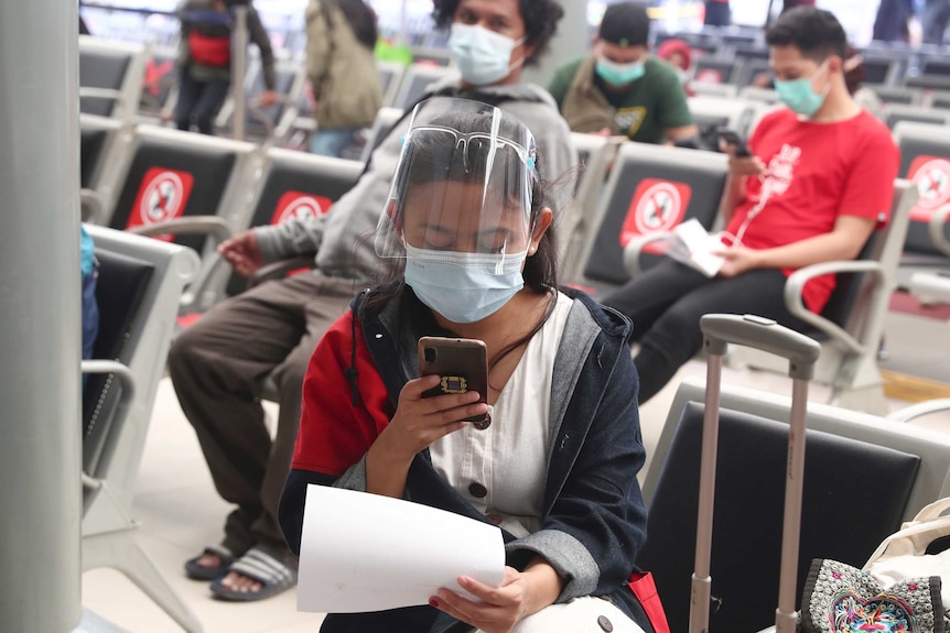 People sit spaced apart as they wait for a coronavirus test