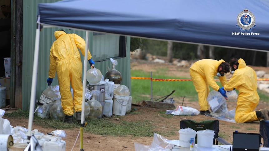 People in yellow jumpsuits put items into bags