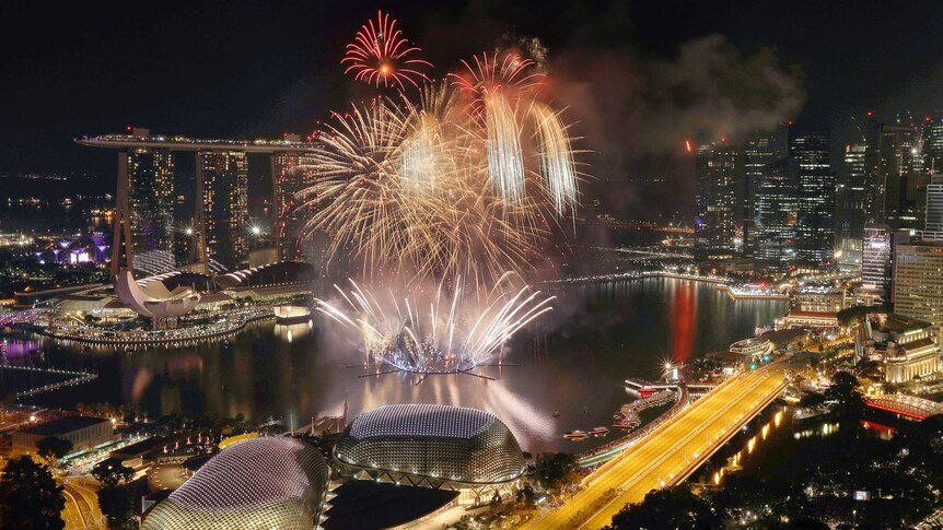Fireworks explode above Singapore's financial district at the stroke of midnight to mark the New Year.