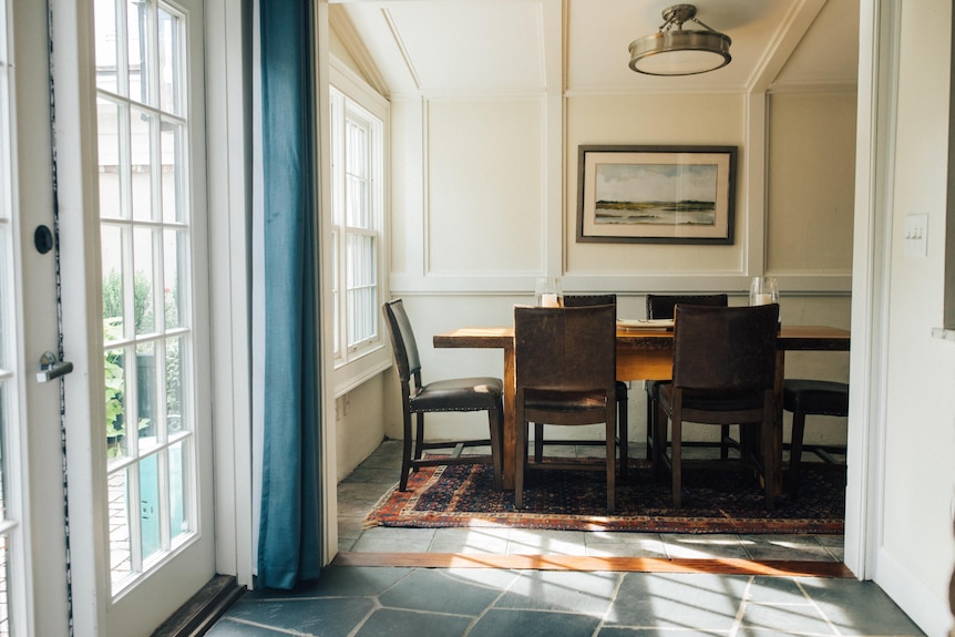 A traditional dining room with big, french windows.