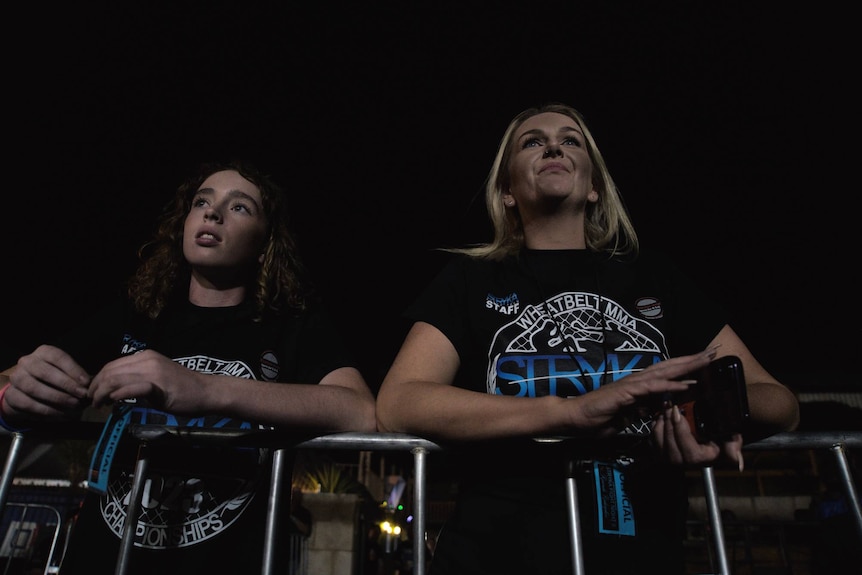 Two girls watching a boxing fight 