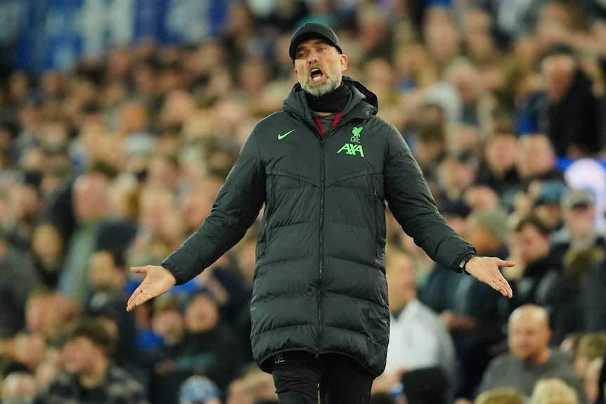 Liverpool manager Jurgen Klopp shouts and puts his arms out in a questioning gesture during a match.