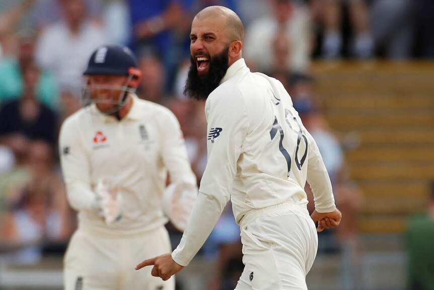 A bowler yells in triumph and points his finger after taking a wicket.