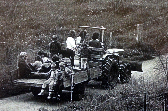 Children ride on a trailer on the back of a tractor at Cowsnest in the 1980s