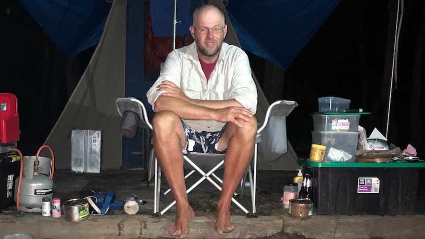 Ski instructor Phil O'Neill sitting in his camp on the Clyde River in NSW.