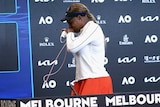 Serena Williams stands as she leaves a media conference at the Australian Open.