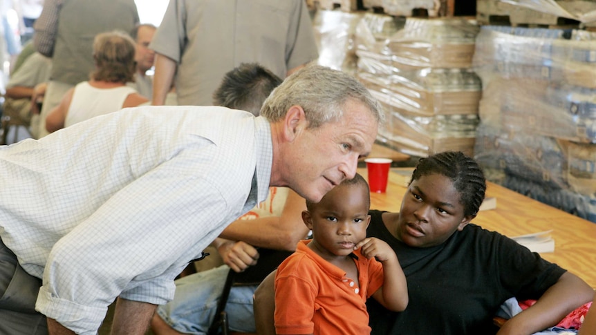 George Bush leans over to talk to a mother and child at a hurricane relief centre