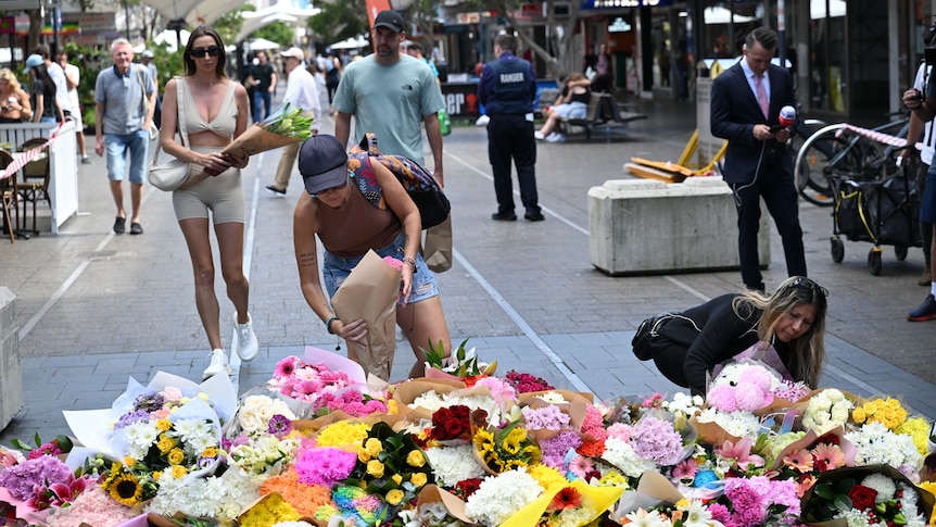 People lay flowers in a mall.