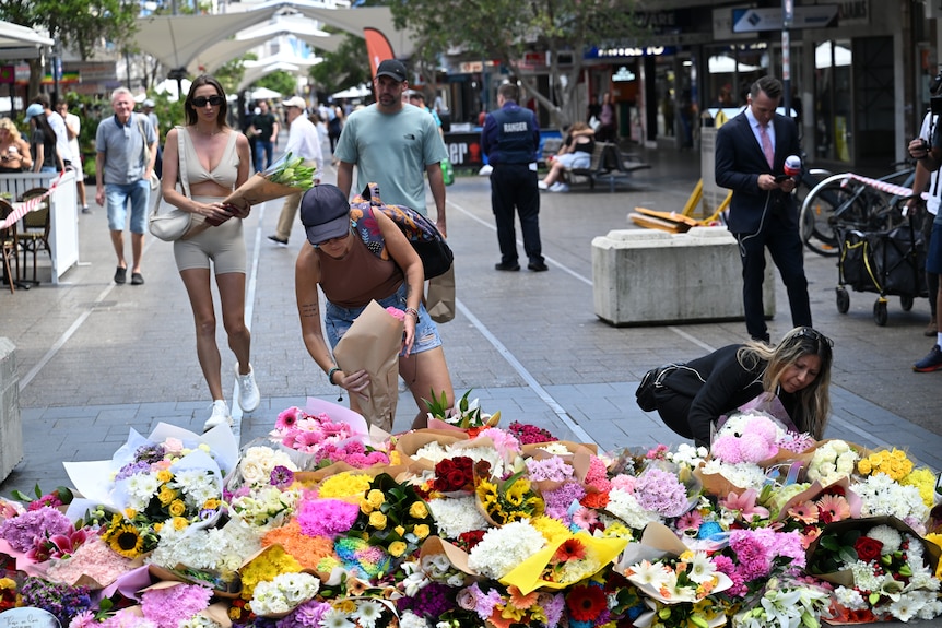 People lay flowers in a mall.