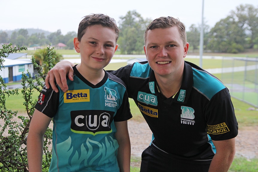 Riley Parsons, 10, with Brisbane Heat batsman Max Bryant. Both are in cricket gear