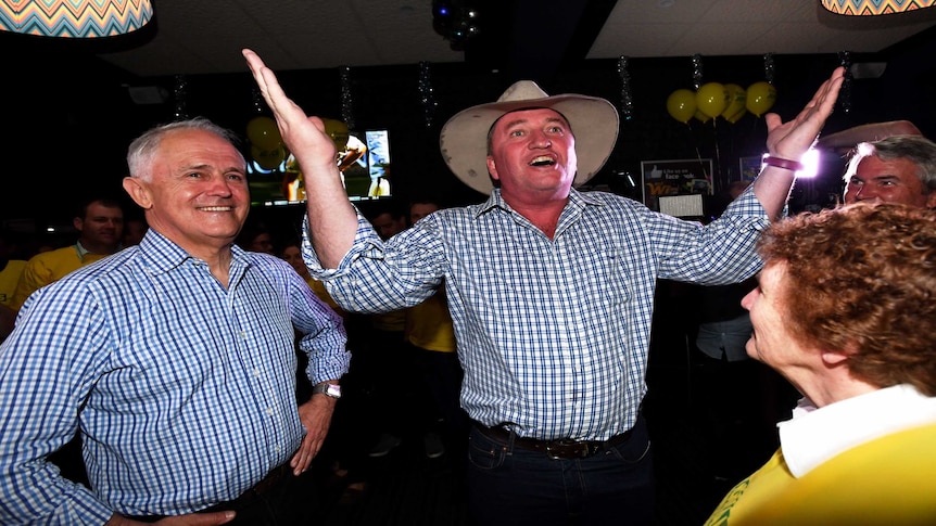 Barnaby Joyce with his arms held wide, Malcolm Turnbull stands beside him.
