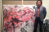 Hobart-based Chinese artist Chen Ping with one of his paintings.
