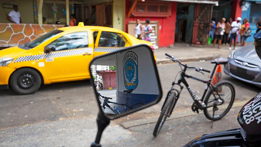 Police Motorbike's side mirror reflects the police sign in the background.