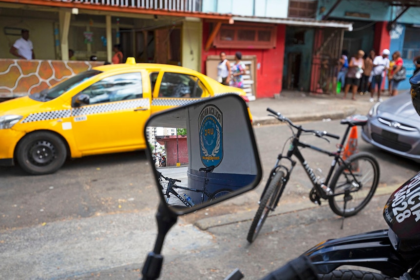 Police Motorbike's side mirror reflects the police sign in the background.