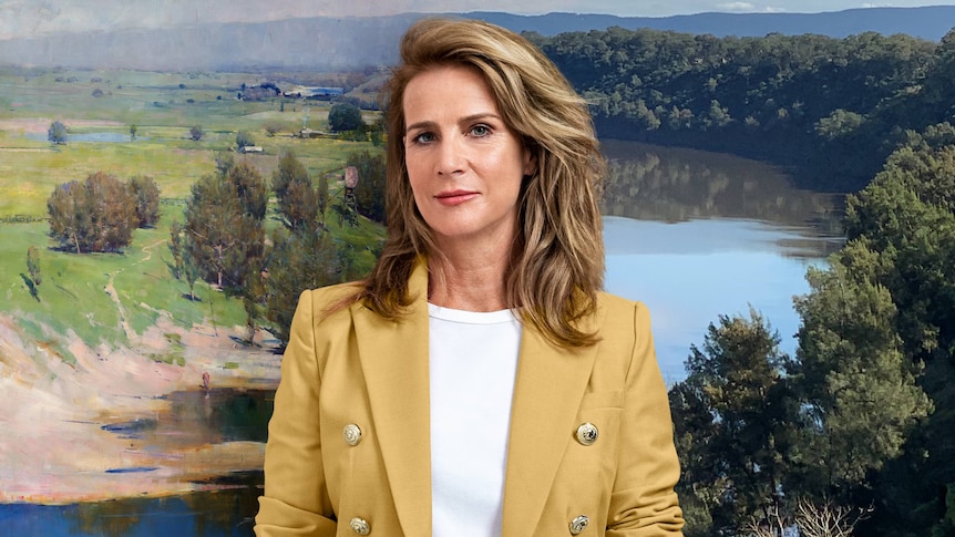 White woman with blonde hair wears yellow blazer over white shirt in front of a composite of a landscape photo and painting
