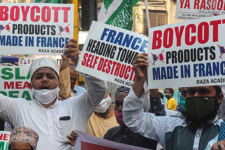 Muslims shout slogans as they hold placards calling for a boycott on French products.