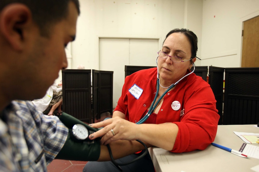 A nurse checks a man's blood pressure.