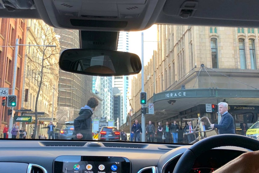 from the inside of a car, a man is seen on the street