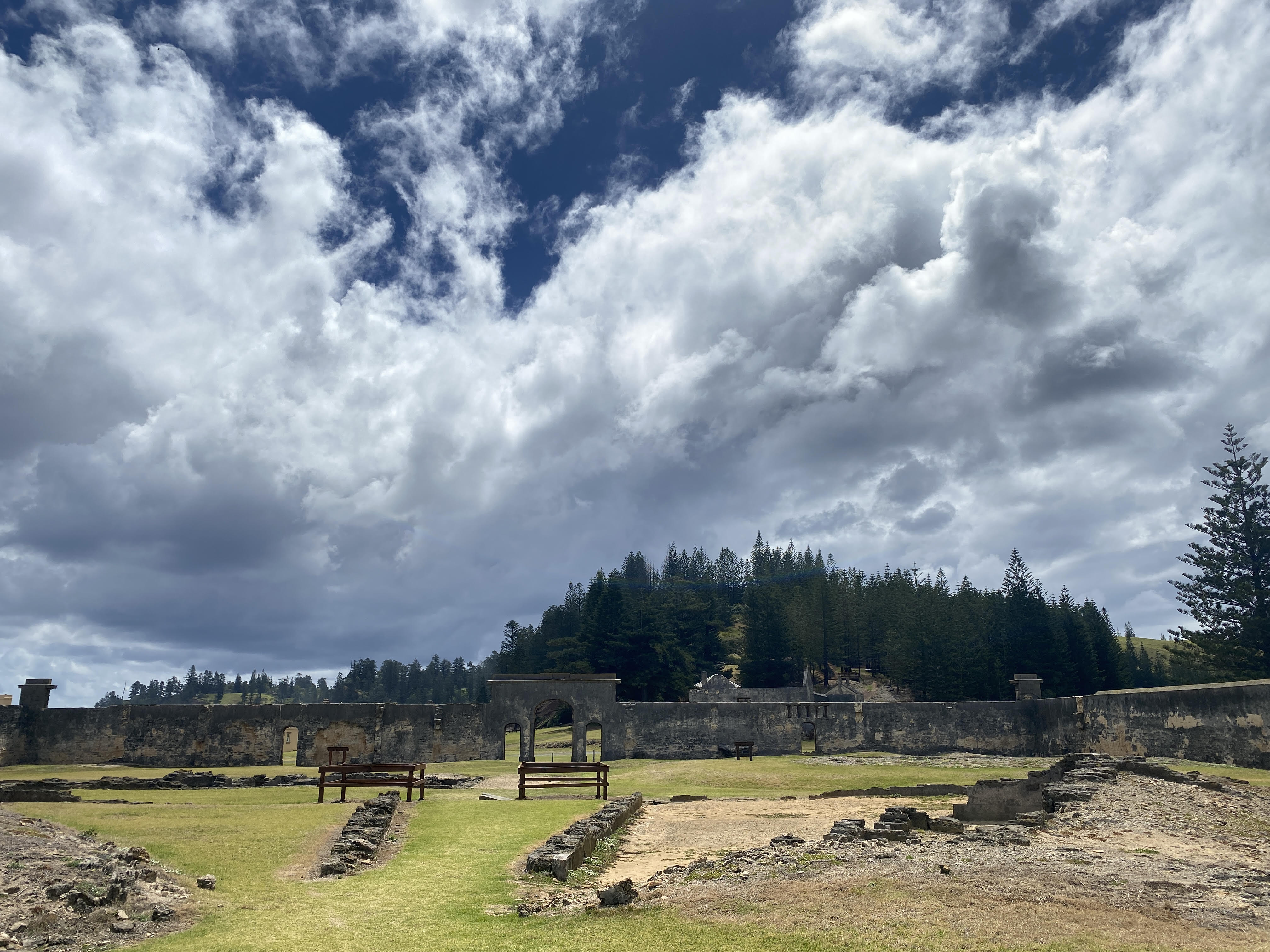 A shot of cement ruins against a backdrop of greenery and blue sky 