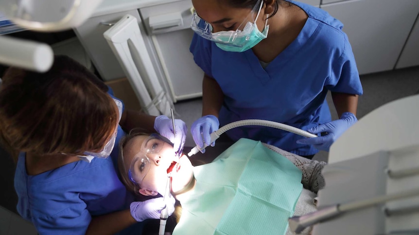 Woman with two dentists