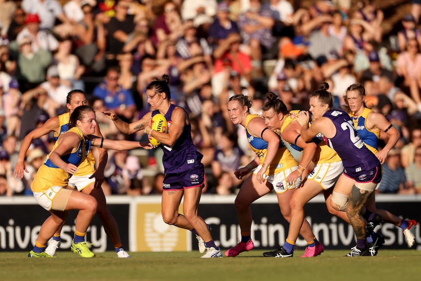 Kiara Bowers surrounded by West Coast players.