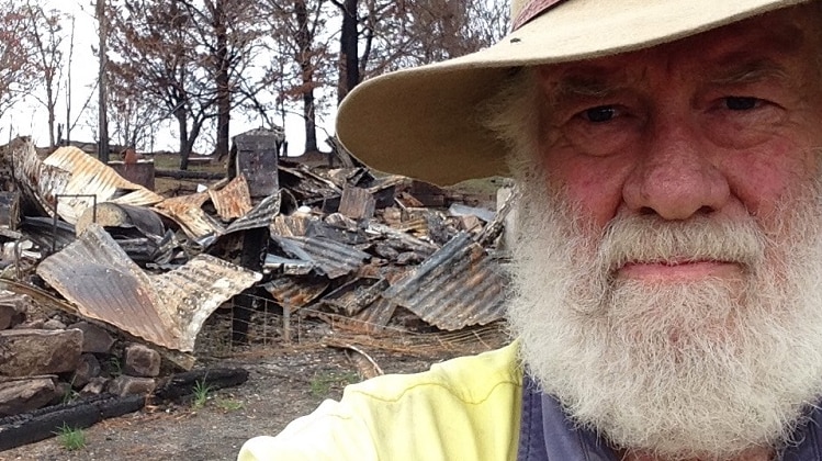 Farmer John Field in front of the remains on a house.
